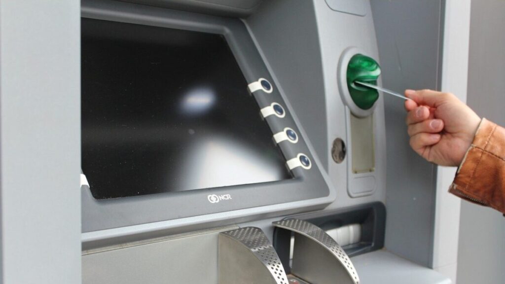 ATMにカードを挿入している人