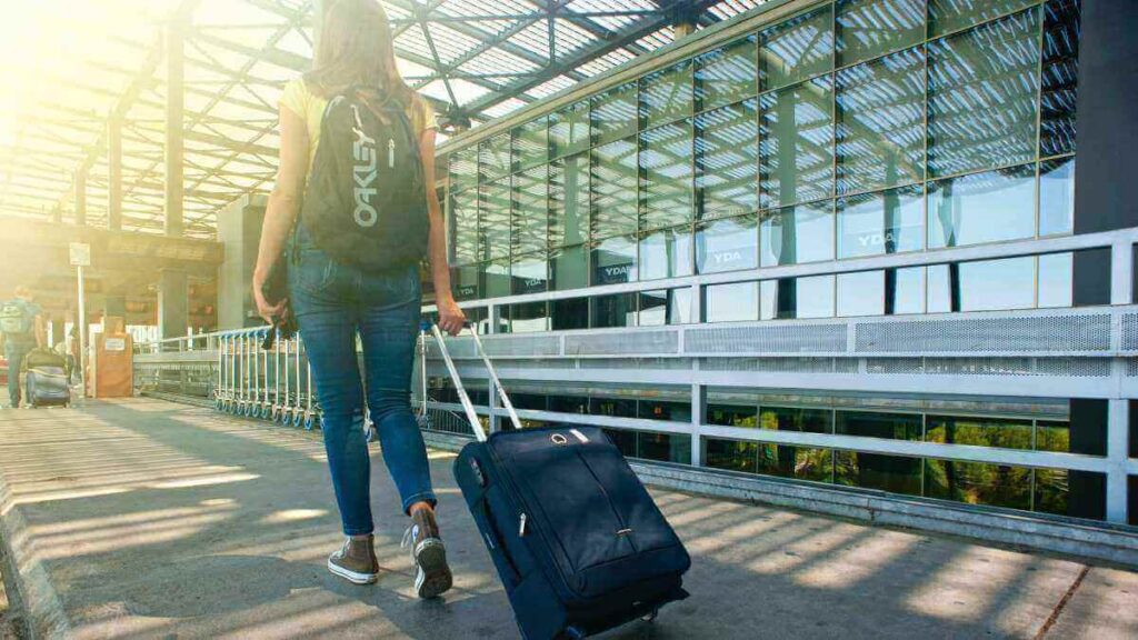 空港でスーツケースを引く女性